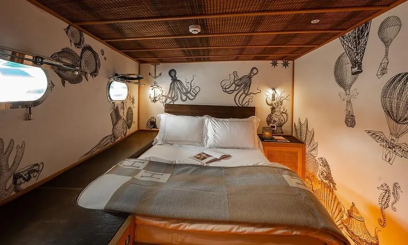 27 M Deluxe Gulet Yacht Photos Pics Cozy cabin interior of 2003 Custom Made Motorsailor with nautical-themed wall art.