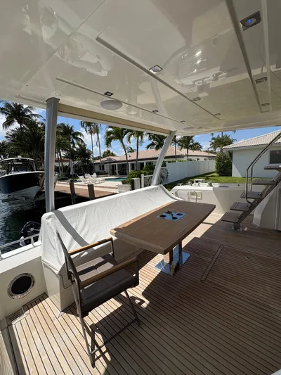  Yacht Photos Pics Luxury yacht deck with seating area, Prestige 680, 2018 model, docked near waterfront homes.