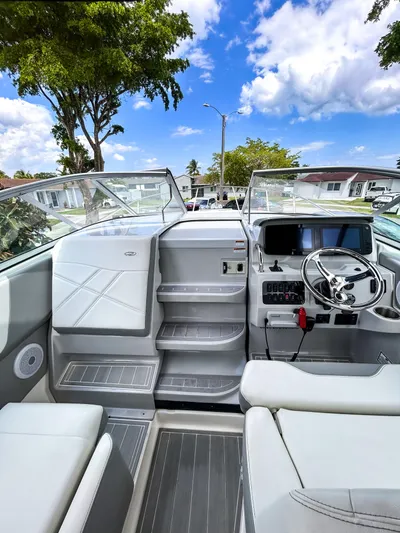  Yacht Photos Pics 2023 Regal 26 XO boat interior with modern dashboard and seating under a clear blue sky.