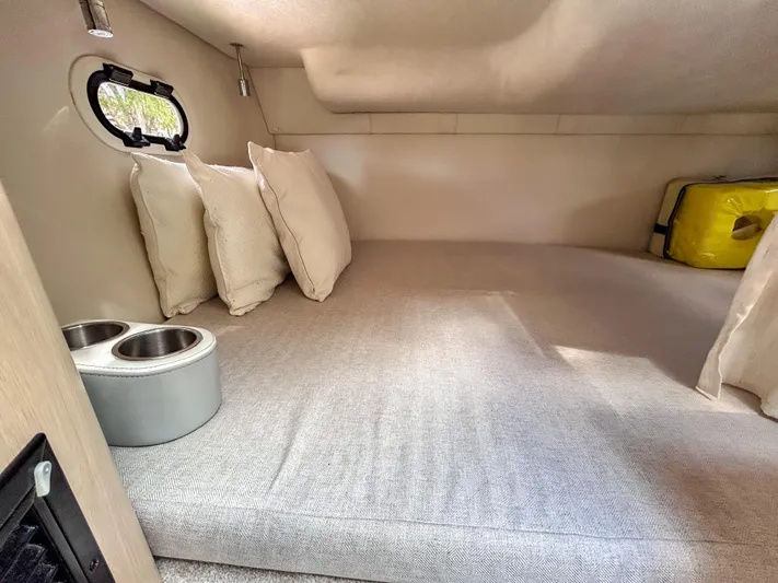  Yacht Photos Pics Cozy cabin interior of 2023 Regal 26 XO boat with cushions and porthole.