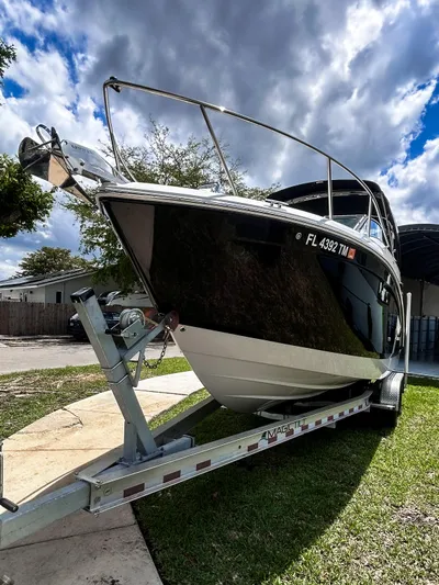  Yacht Photos Pics 2023 Regal 26 XO boat on trailer under cloudy sky.