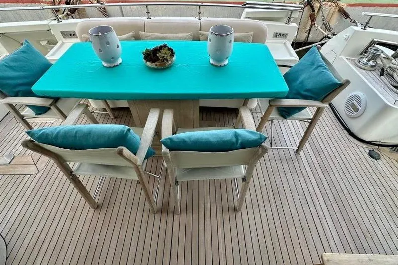  Yacht Photos Pics Outdoor dining area on 2008 Sanlorenzo 62 yacht with turquoise table and cushions.