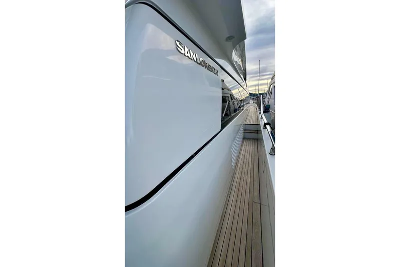  Yacht Photos Pics Side view of a 2008 Sanlorenzo 62 yacht with sleek white exterior and wooden deck.