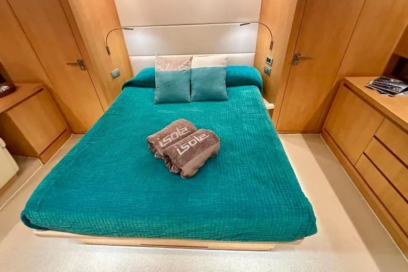  Yacht Photos Pics Luxurious bedroom interior of 2008 Sanlorenzo 62 yacht with teal bedding and wooden accents.