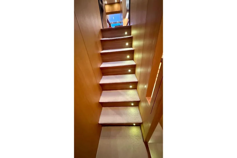  Yacht Photos Pics Illuminated wooden staircase inside 2008 Sanlorenzo 62 yacht, showcasing elegant interior design.