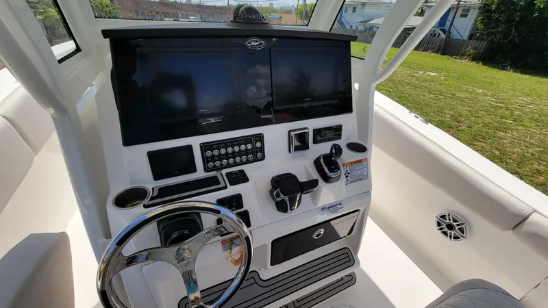  Yacht Photos Pics 2024 Sea Fox 288 Commander boat dashboard with dual screens and steering wheel.
