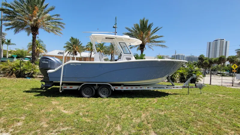  Yacht Photos Pics 2024 Sea Fox 288 Commander boat on trailer, parked outdoors with palm trees in background.
