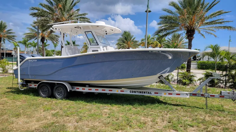  Yacht Photos Pics 2024 Sea Fox 288 Commander boat on trailer, surrounded by palm trees and blue sky.