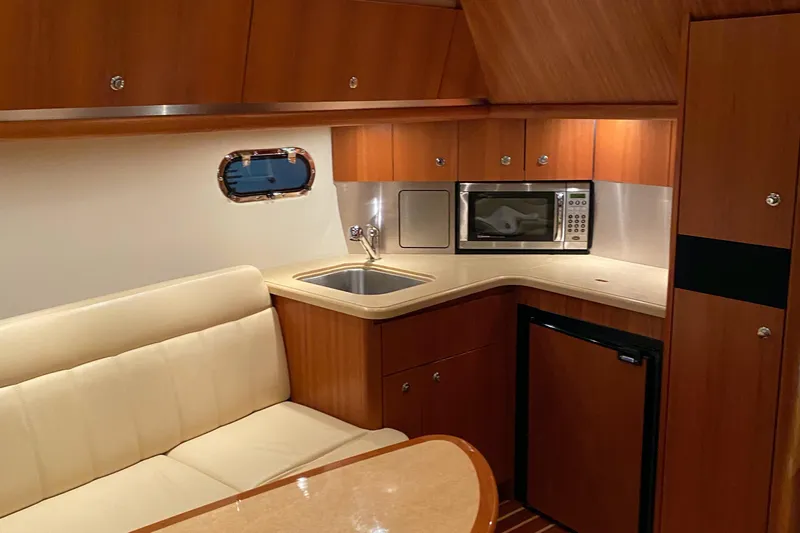  Yacht Photos Pics 2005 Tiara Yachts 3600 Sovran interior with kitchenette, featuring sink, microwave, and seating area.