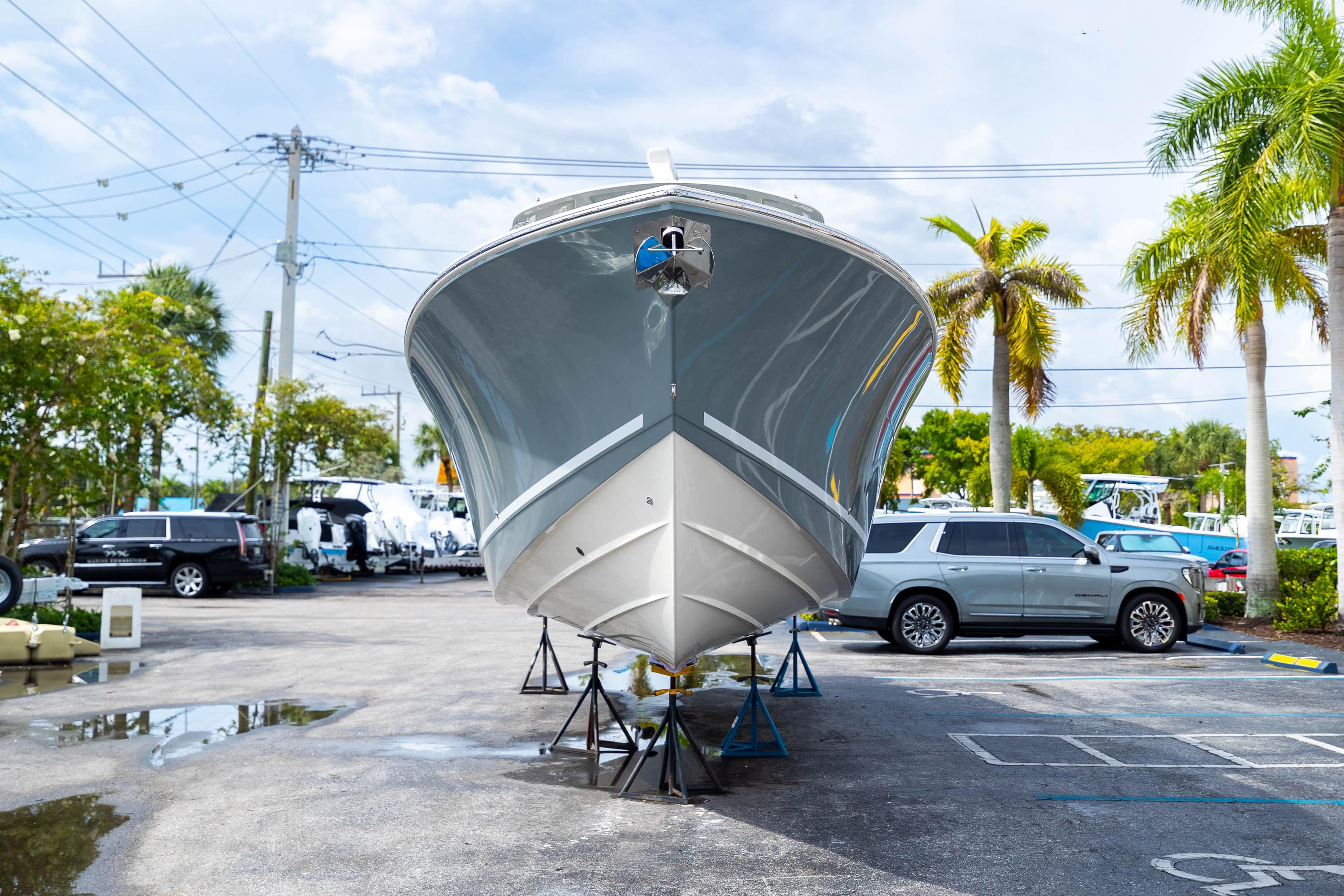 2023 Cobia 350 Center Console boat on stands in a parking lot with palm trees.