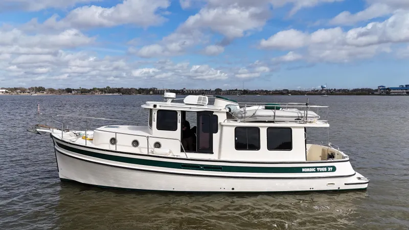 Ms. Moneypenny Yacht Photos Pics 2001 Nordic Tug 37 boat on calm water under a partly cloudy sky.