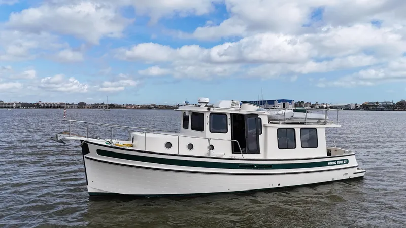 Ms. Moneypenny Yacht Photos Pics 2001 Nordic Tug 37 boat on calm water under a partly cloudy sky.