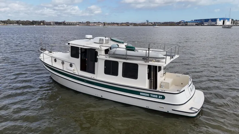 Ms. Moneypenny Yacht Photos Pics 2001 Nordic Tug 37 boat on calm water, side view with clear sky background.