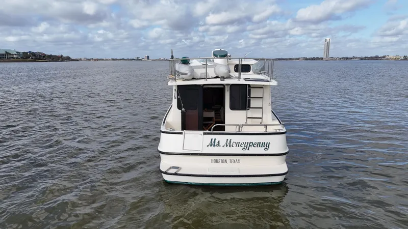 Ms. Moneypenny Yacht Photos Pics 2001 Nordic Tug 37 boat named "Ms. Moneypenny" on open water under a cloudy sky.