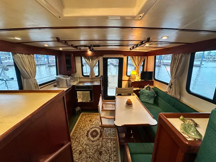 Ms. Moneypenny Yacht Photos Pics Interior of 2001 Nordic Tug 37, featuring cozy dining area and panoramic windows.