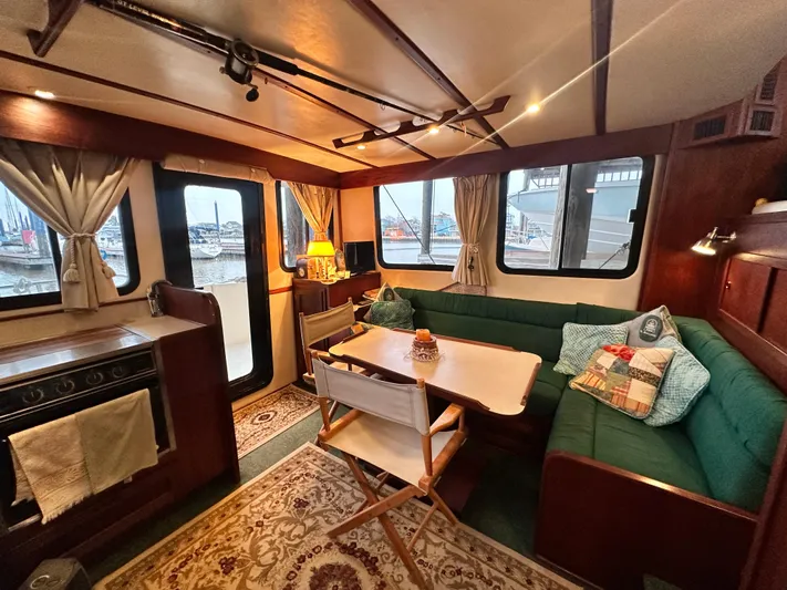 Ms. Moneypenny Yacht Photos Pics Cozy interior of a 2001 Nordic Tug 37 with dining area and windows.