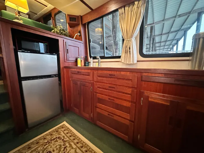Ms. Moneypenny Yacht Photos Pics Interior of a 2001 Nordic Tug 37, featuring wooden cabinetry and a compact refrigerator.
