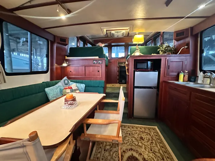 Ms. Moneypenny Yacht Photos Pics Interior of a 2001 Nordic Tug 37, featuring a cozy dining area and compact kitchen.