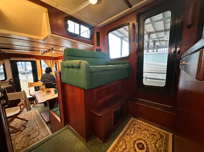 Ms. Moneypenny Yacht Photos Pics Interior of 2001 Nordic Tug 37, featuring cozy seating and wooden accents.