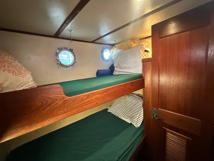 Ms. Moneypenny Yacht Photos Pics Bunk beds in 2001 Nordic Tug 37 cabin with portholes and wooden door.