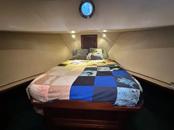 Ms. Moneypenny Yacht Photos Pics Cozy cabin interior of 2001 Nordic Tug 37 with a colorful patchwork quilt.