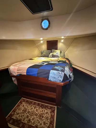 Ms. Moneypenny Yacht Photos Pics Cozy cabin interior of 2001 Nordic Tug 37 with a colorful quilted bedspread.