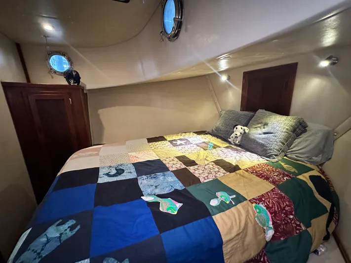 Ms. Moneypenny Yacht Photos Pics Cozy cabin interior of 2001 Nordic Tug 37 with colorful patchwork quilt on bed.
