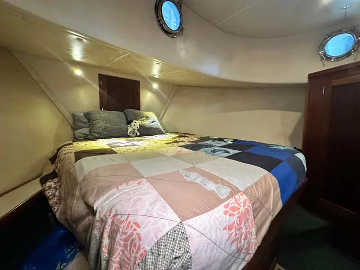Ms. Moneypenny Yacht Photos Pics Cozy cabin interior of 2001 Nordic Tug 37 with a colorful quilted bedspread.