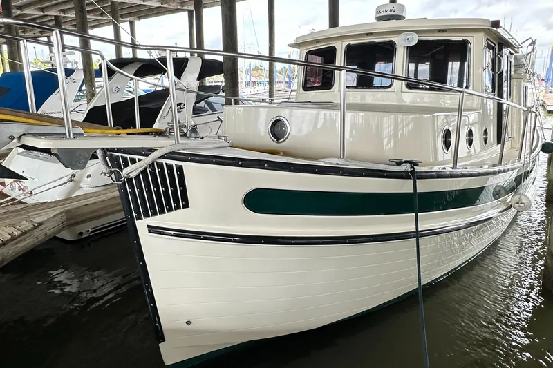 Ms. Moneypenny Yacht Photos Pics 2001 Nordic Tug 37 docked in a marina, showcasing classic design and sturdy build.