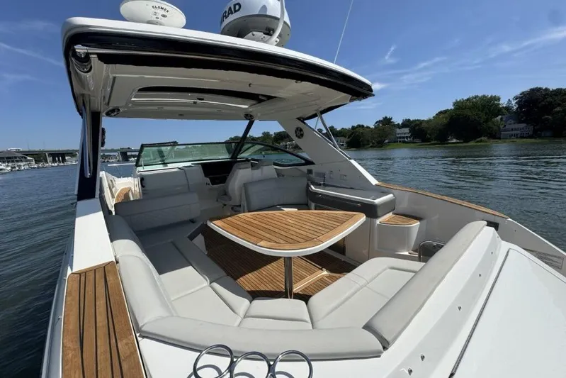  Yacht Photos Pics 2020 Sea Ray Sundancer 320 Outboard with spacious seating and wooden table on a sunny day.