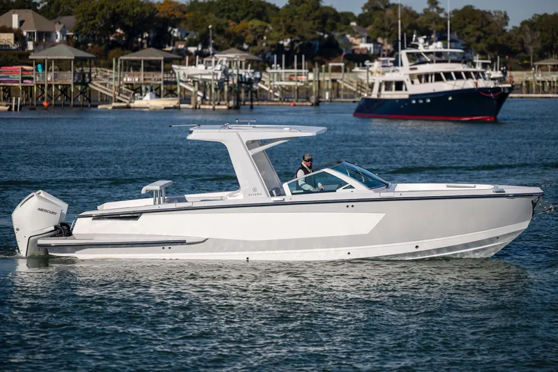  Yacht Photos Pics 2023 Aviara AV32 OB boat cruising on a calm waterway with scenic background.