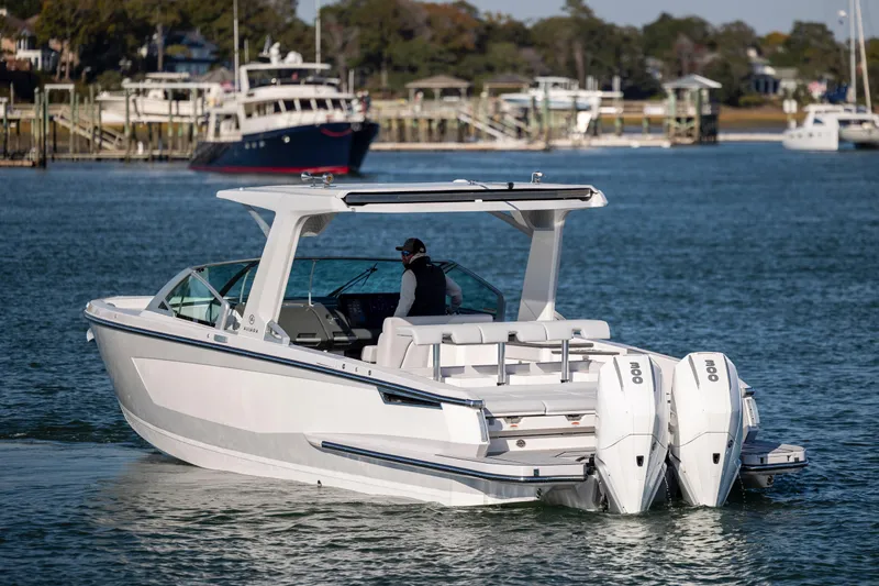  Yacht Photos Pics 2023 Aviara AV32 OB boat cruising on a calm waterway with scenic background.
