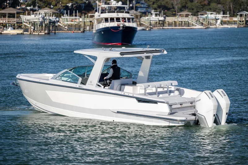  Yacht Photos Pics 2023 Aviara AV32 OB boat cruising on a calm waterway with scenic background.