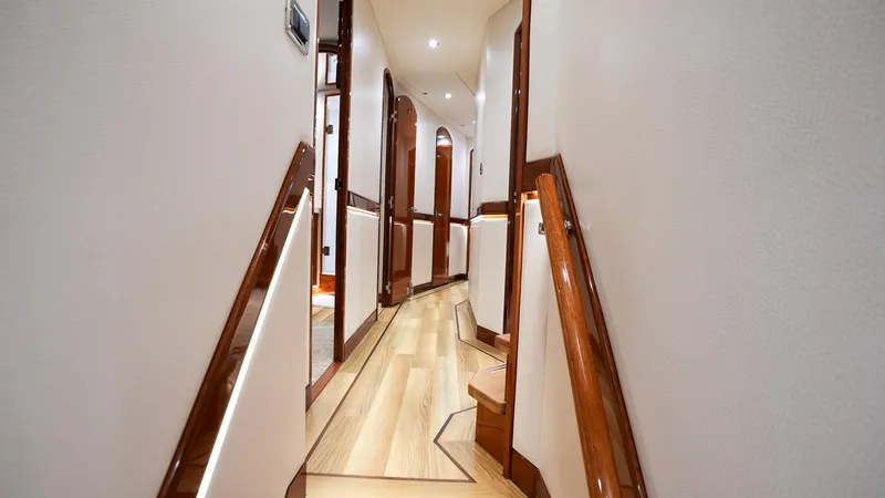  Yacht Photos Pics Luxurious interior hallway of 2024 Hatteras GT70 yacht with elegant wood finishes.