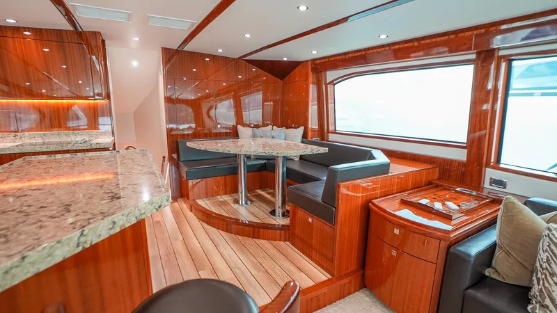  Yacht Photos Pics Luxurious interior of 2024 Hatteras GT70 yacht with elegant wood finishes and modern seating.