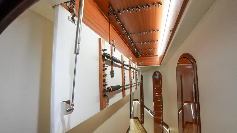  Yacht Photos Pics Interior view of 2024 Hatteras GT70 yacht, showcasing elegant wood paneling and fishing rod storage.