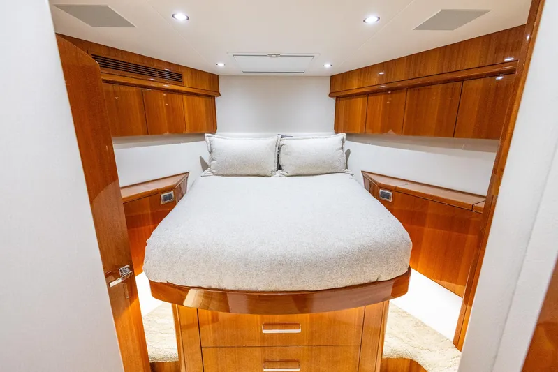  Yacht Photos Pics Luxurious 2024 Hatteras GT70 yacht bedroom with elegant wood finish and cozy bedding.