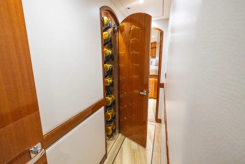  Yacht Photos Pics Luxurious interior hallway of 2024 Hatteras GT70 yacht with wooden doors and fishing gear storage.