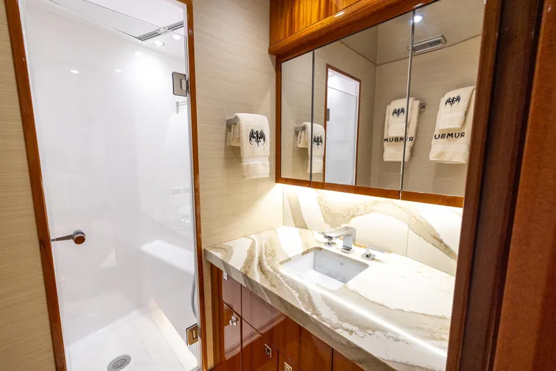  Yacht Photos Pics Luxurious bathroom in 2024 Hatteras GT70 yacht with marble countertop and modern shower.