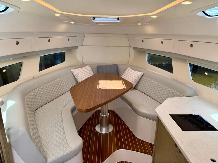  Yacht Photos Pics Luxurious interior of 2026 Intrepid 438 Evolution yacht with elegant seating and wooden table.