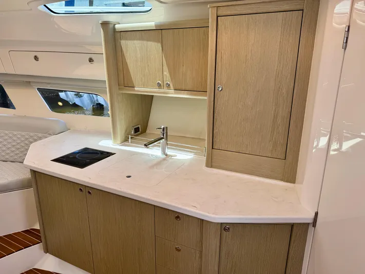  Yacht Photos Pics Modern kitchen area in 2026 Intrepid 438 Evolution yacht with wood cabinetry and sleek countertop.