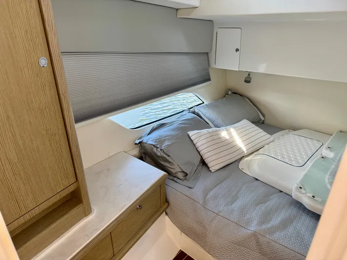  Yacht Photos Pics Cozy cabin interior of 2026 Intrepid 438 Evolution yacht with bed and wooden cabinetry.