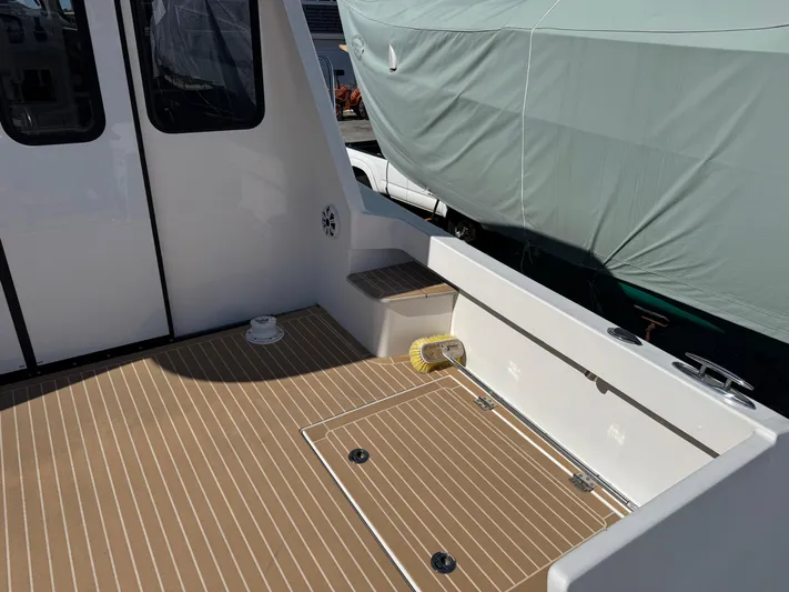 Resolute Yacht Photos Pics Cape Powercat 3500 PH 2020 model boat deck with wood finish and storage hatch.