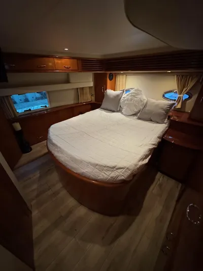  Yacht Photos Pics Interior of 2005 Carver 39 Motor Yacht bedroom with cozy bed and wooden furnishings.