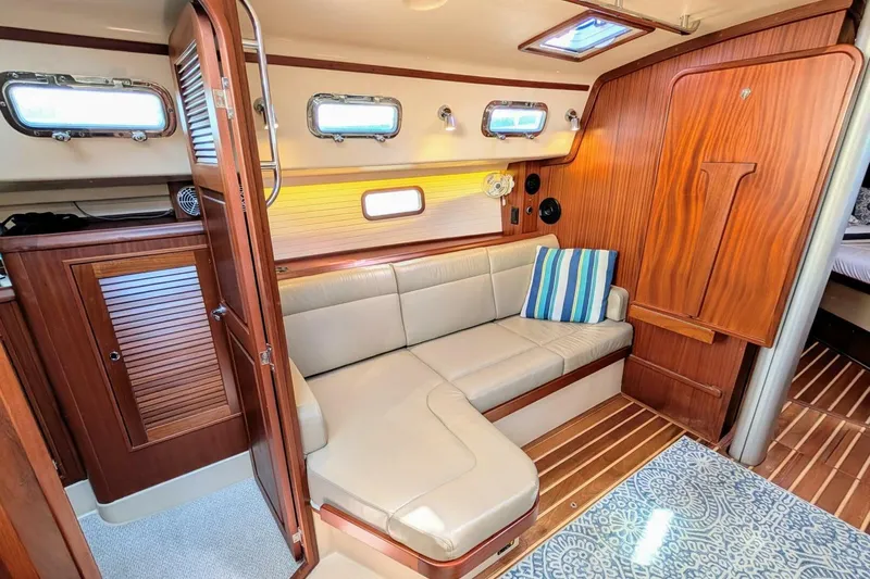 Offline Yacht Photos Pics 2019 Island Packet 349 interior with cozy seating, wooden cabinetry, and nautical decor.
