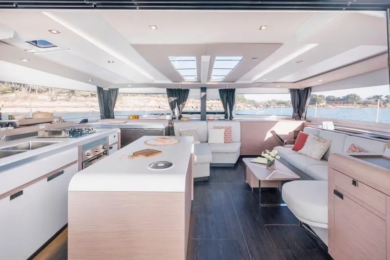  Yacht Photos Pics Luxurious interior of 2025 Fountaine Pajot Catamaran Aura 51 with modern kitchen and seating area.