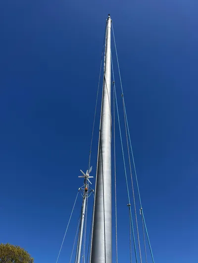 Melodeon Yacht Photos Pics Tall mast of 2006 Custom Seakindly Marine Tucker 52 sailboat against clear blue sky.