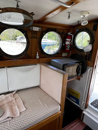 Melodeon Yacht Photos Pics Cozy cabin interior of 2006 Seakindly Marine Tucker 52 with portholes and microwave.