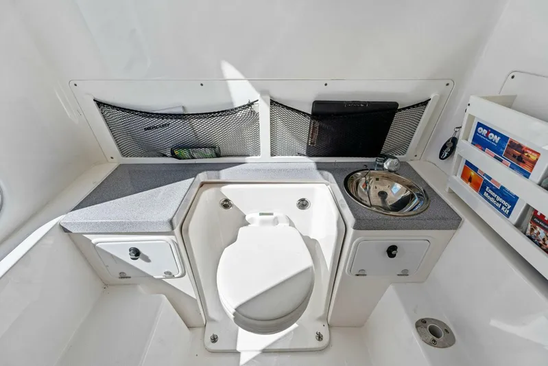 Ohana Yacht Photos Pics 2019 Invincible 42 Open Fisherman boat bathroom with toilet, sink, and storage compartments.