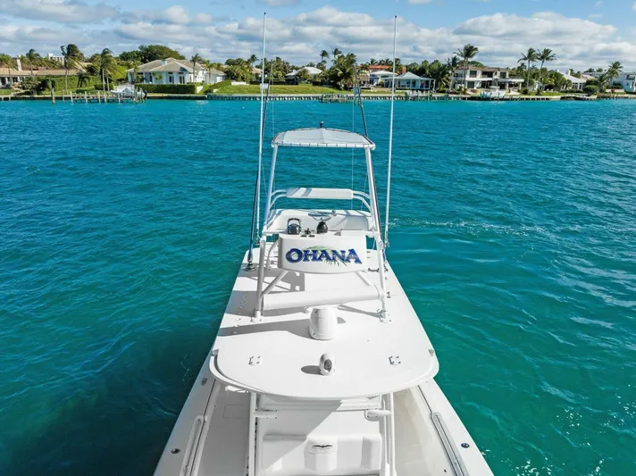 Ohana Yacht Photos Pics 2019 Invincible 42 Open Fisherman boat on clear blue water near coastal homes.